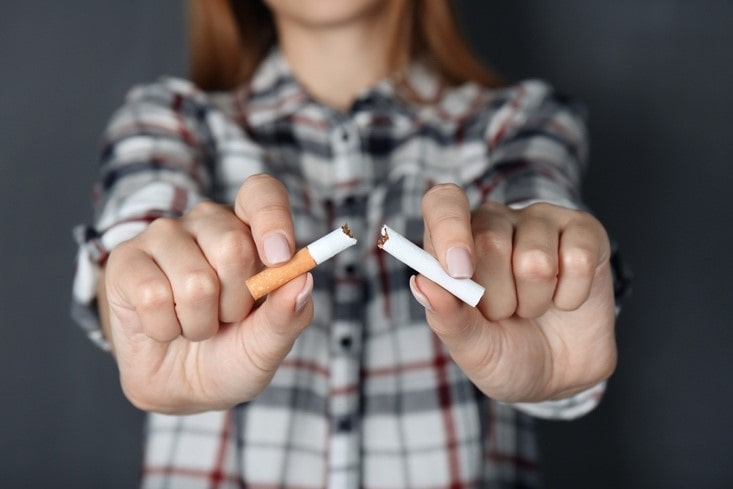 Closeup view of woman breaking cigarette in hands